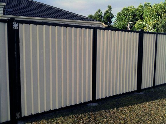 A White And Black Fence With A House In The Background — AAA Fencing & Supplies in Southport, QLD
