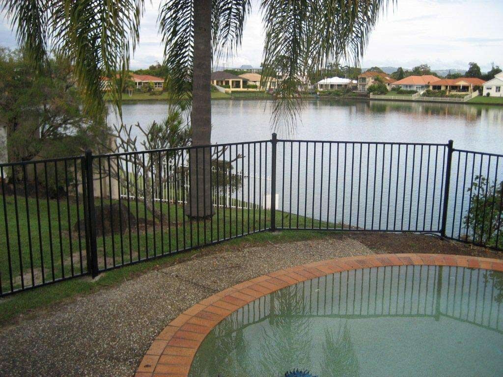 A Fence Surrounds A Pool With A View Of A Lake — AAA Fencing & Supplies in Southport, QLD
