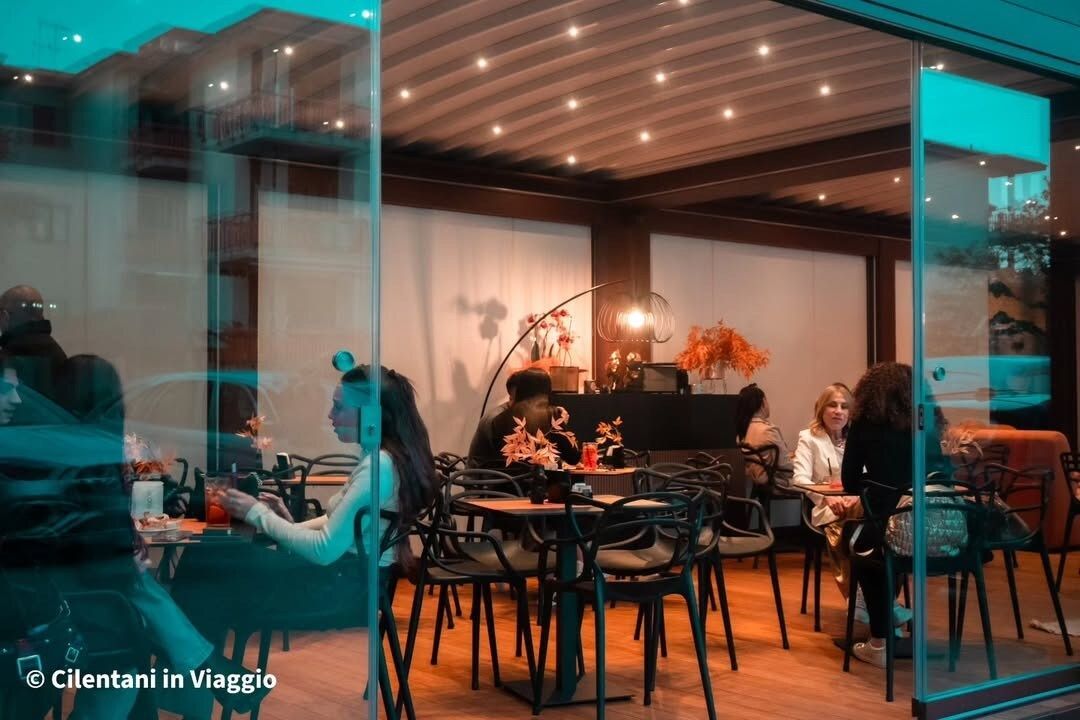 Interno del ristorante con persone sedute ai tavoli, visibili attraverso le vetrate.