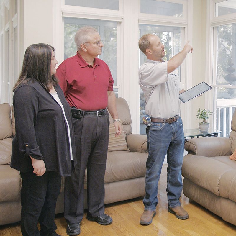 Three people stand in living room