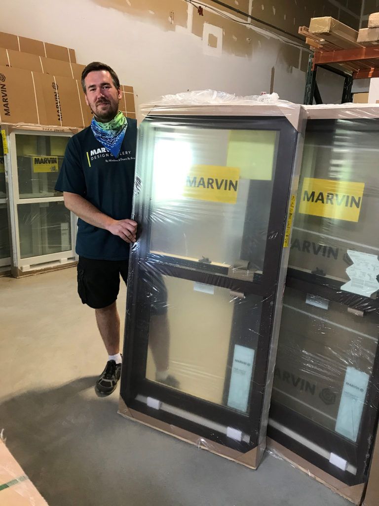 Man standing beside windows