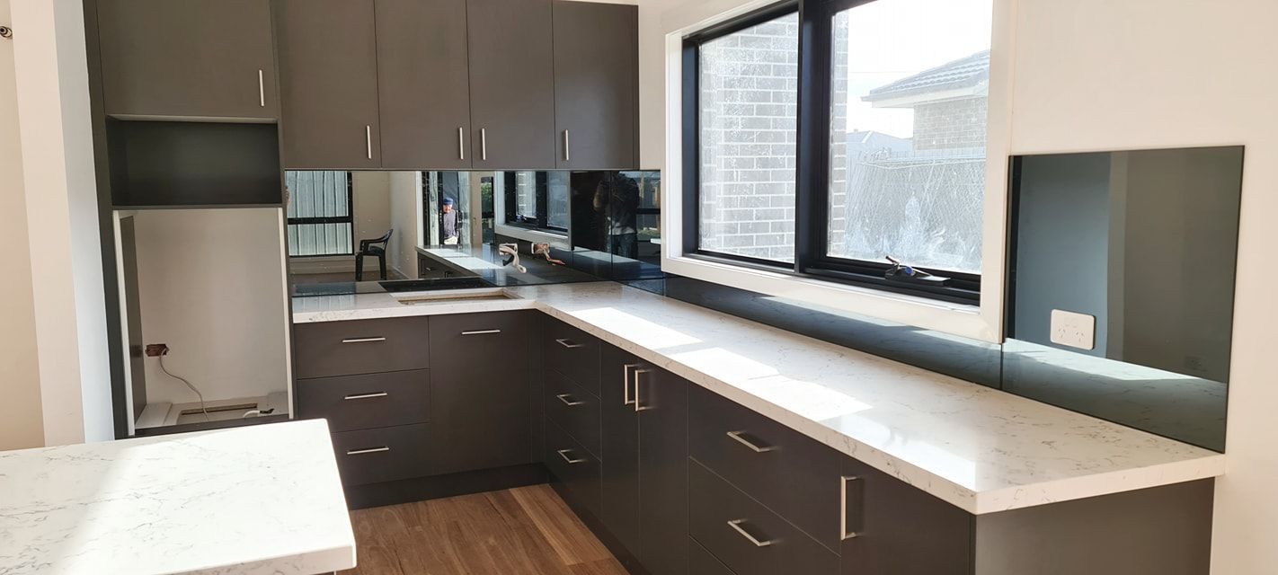 A kitchen with a lot of cabinets and a lot of windows.