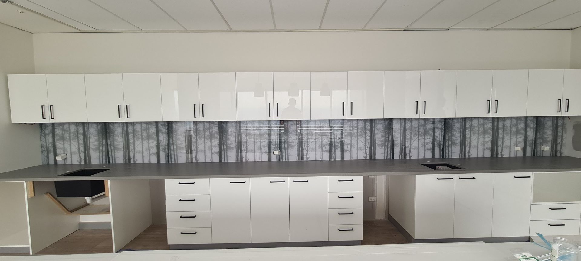 A kitchen with white wooden cabinets and a gray counter top.