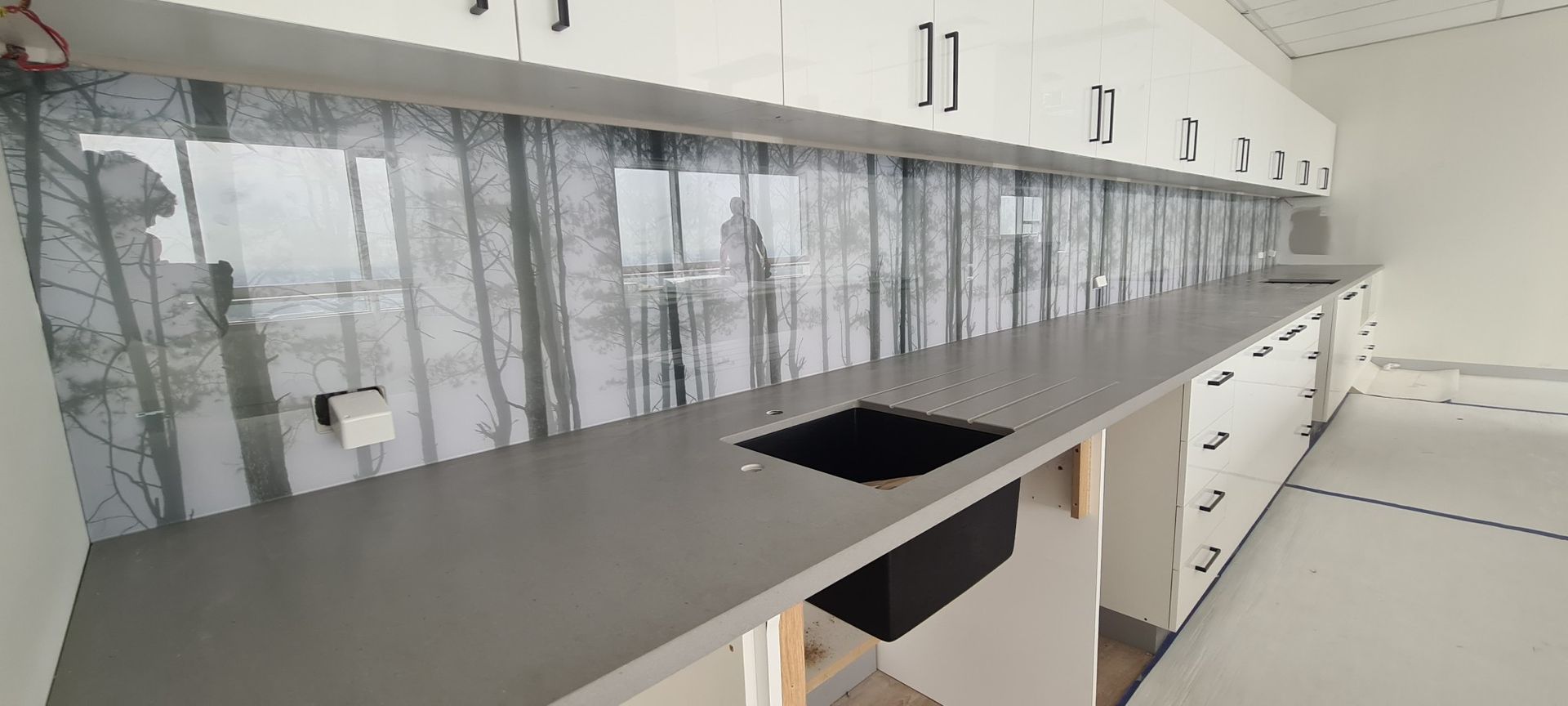 A kitchen with white cabinets and a black sink.