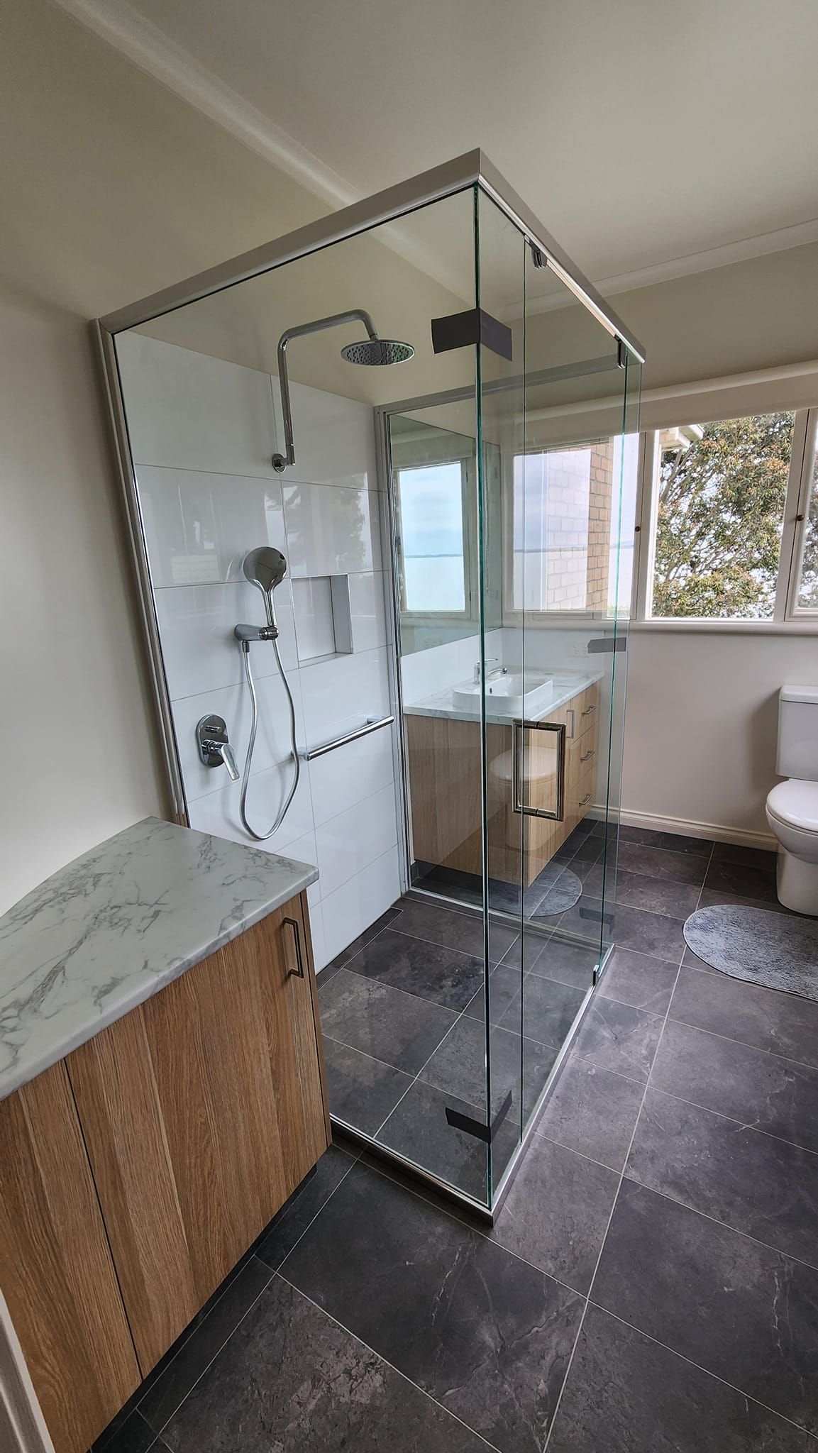 A bathroom with a walk in shower and a toilet.