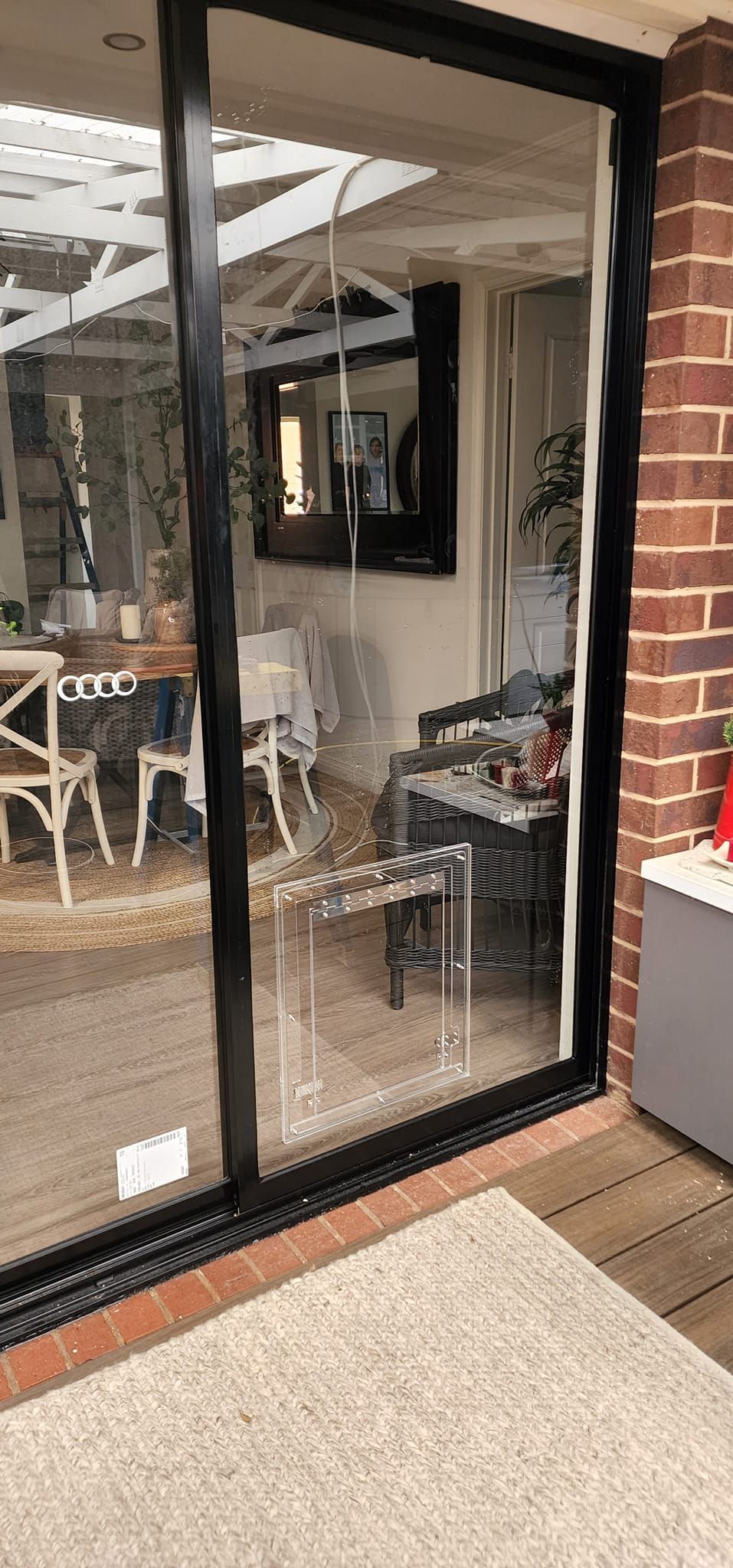 A sliding glass door with a black frame is open to a living room.