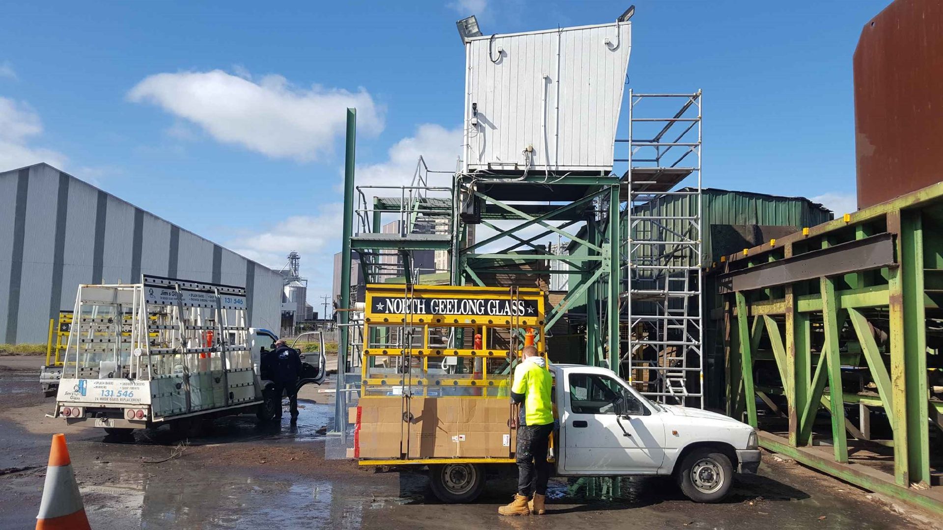 A man is standing next to a white truck in a parking lot.
