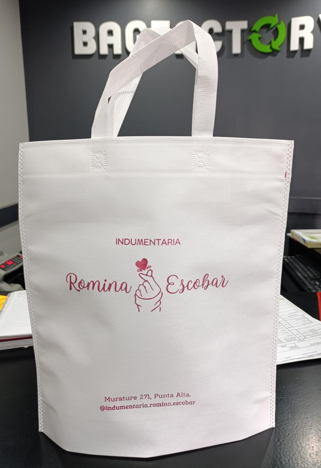 Una bolsa de mano blanca está sobre una mesa en una tienda.