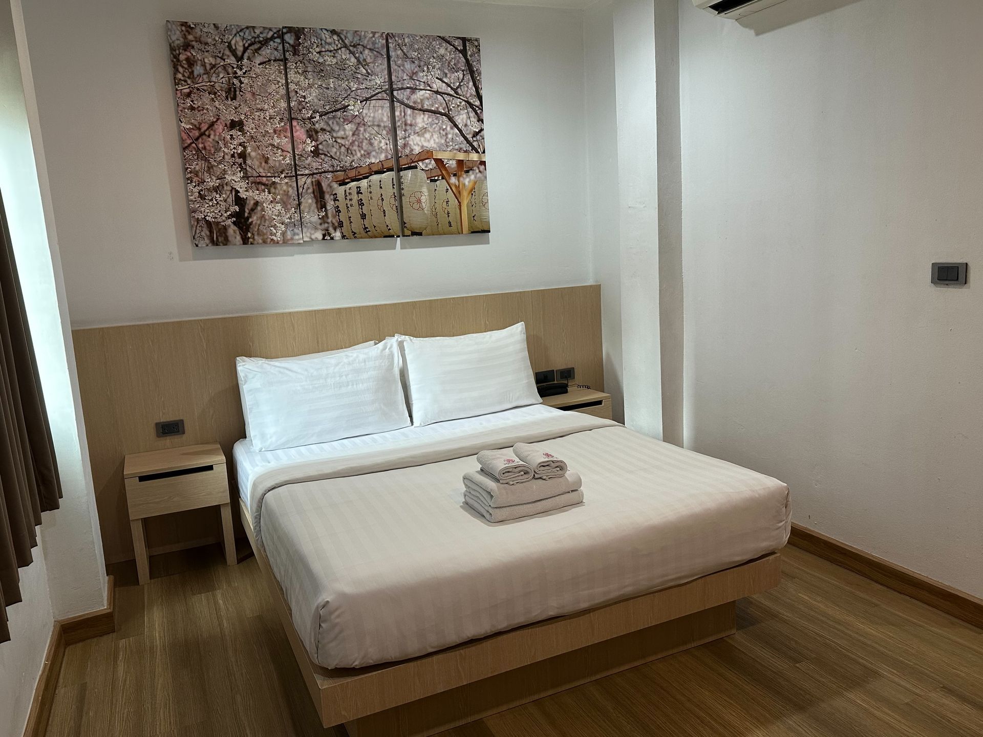 Bedroom with a double bed, two nightstands, and a painting on the wall.