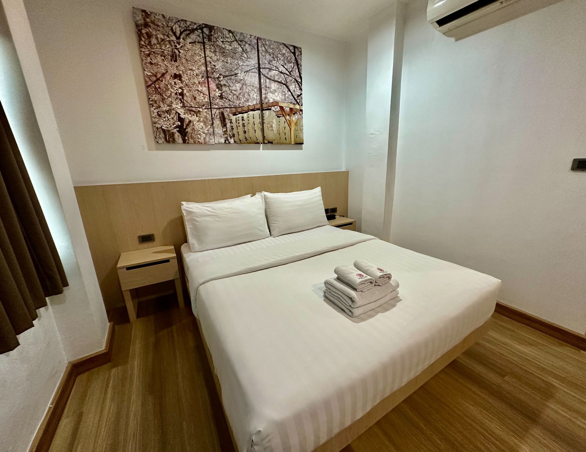 Bedroom with a double bed, nightstands, artwork, and air conditioner.