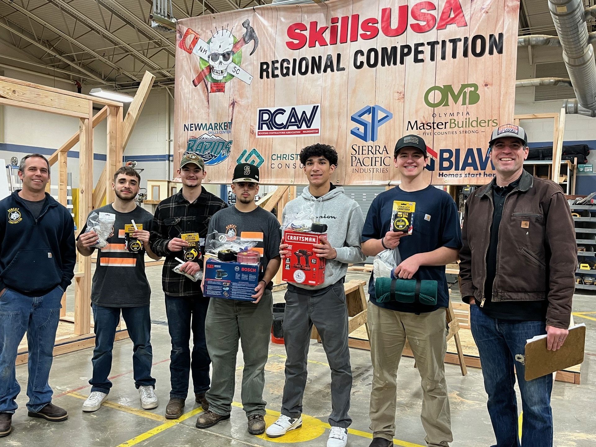 a group of men are standing in front of a sign that says skills usa regional competition .