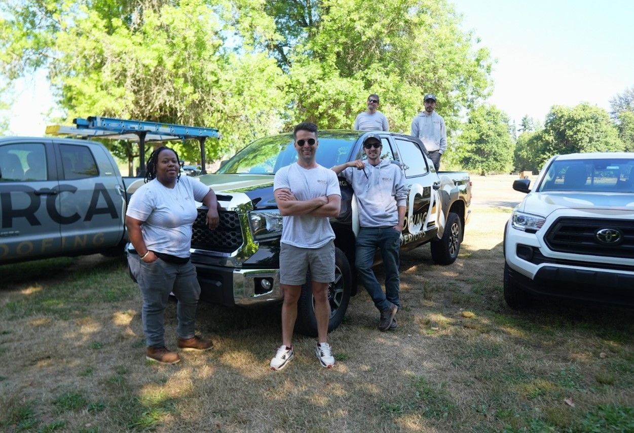 the orca roofing team standing in front of a truck that says rcaw