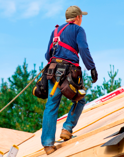 a man wearing a safety harness is standing on a roof