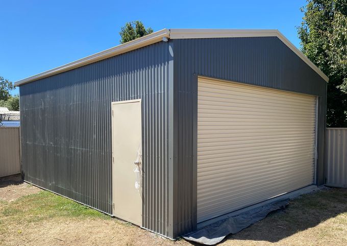 A large blue metal building with a garage door