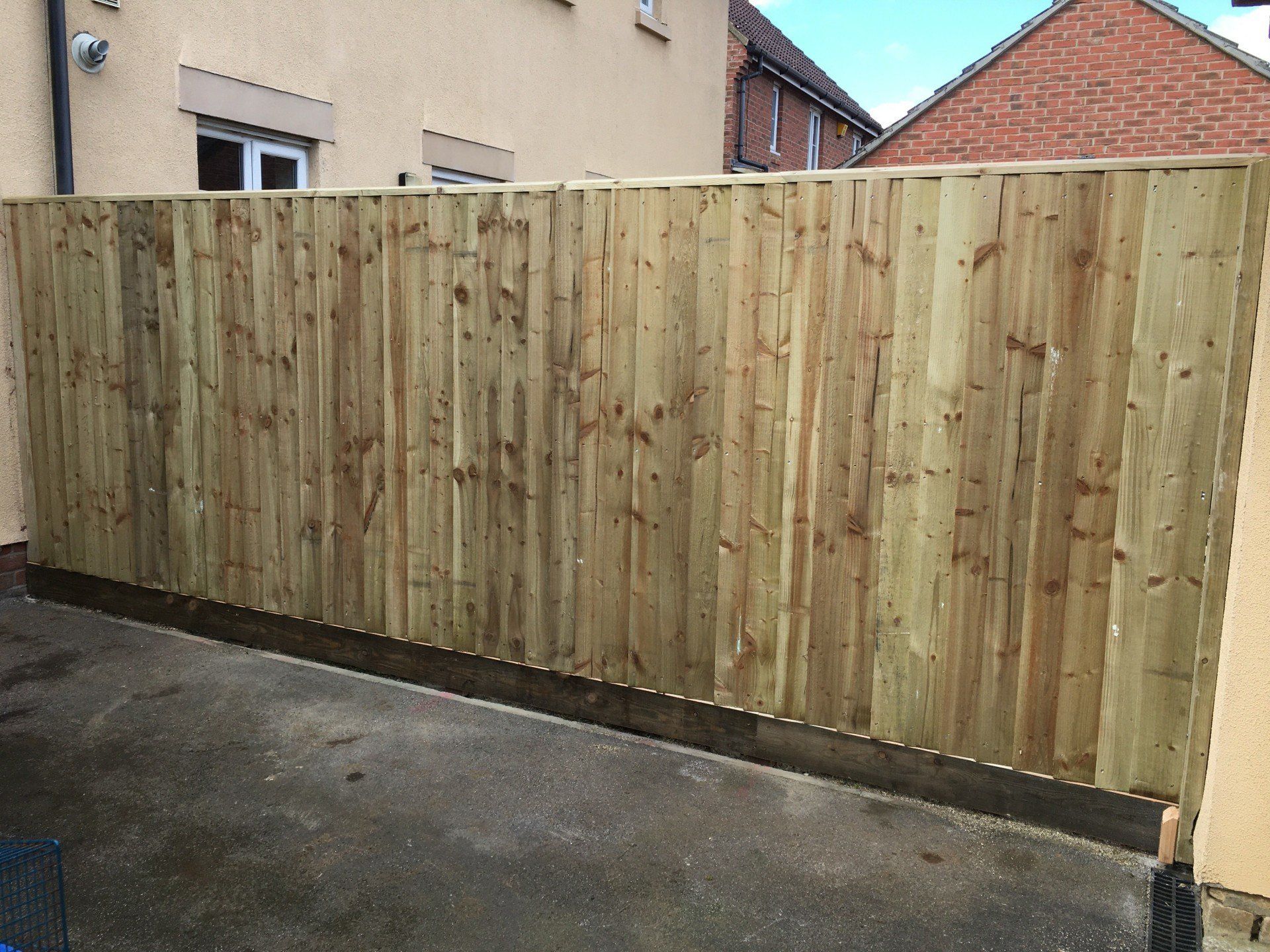 A wooden fence is being built in front of a house.