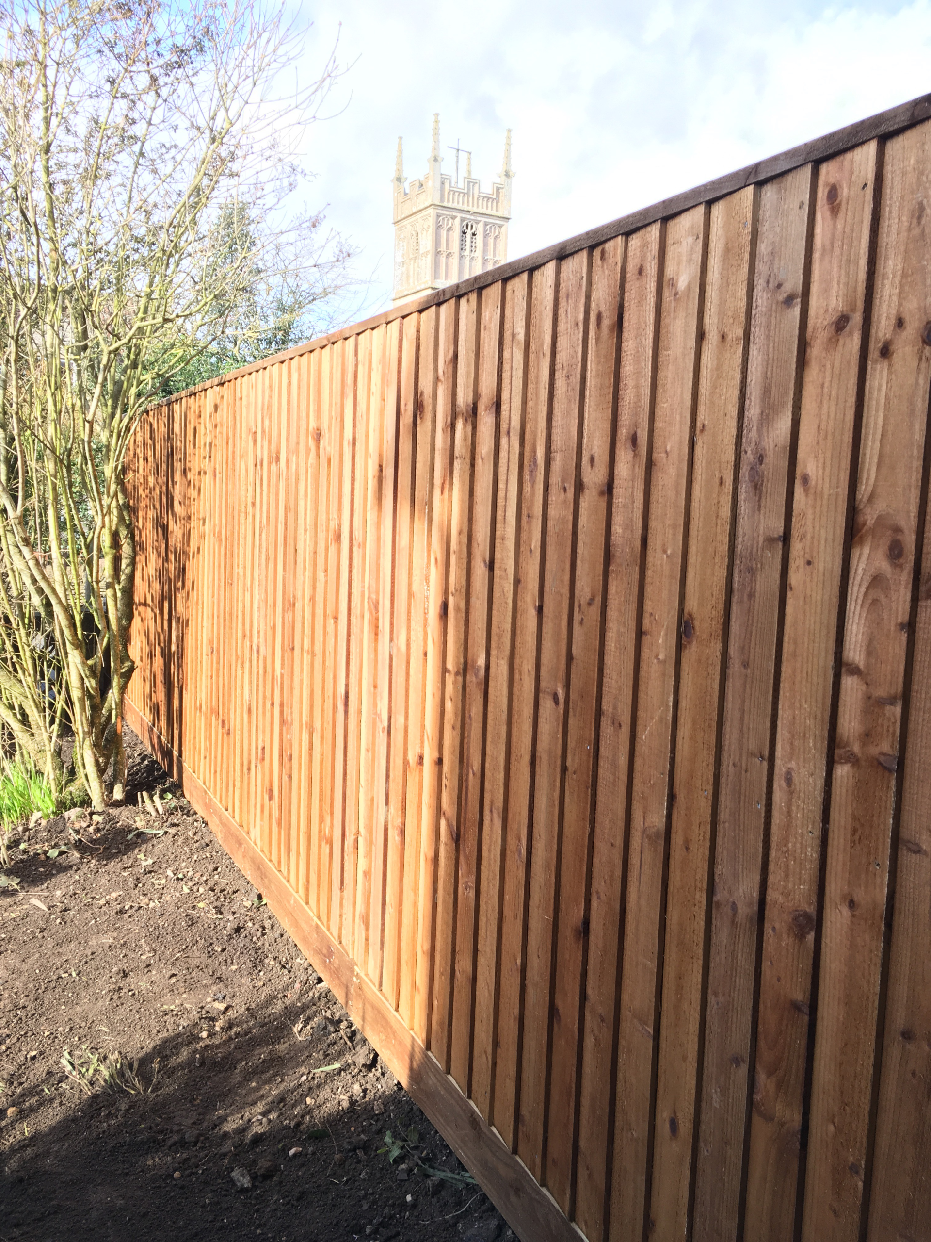 A wooden fence with a church in the background.