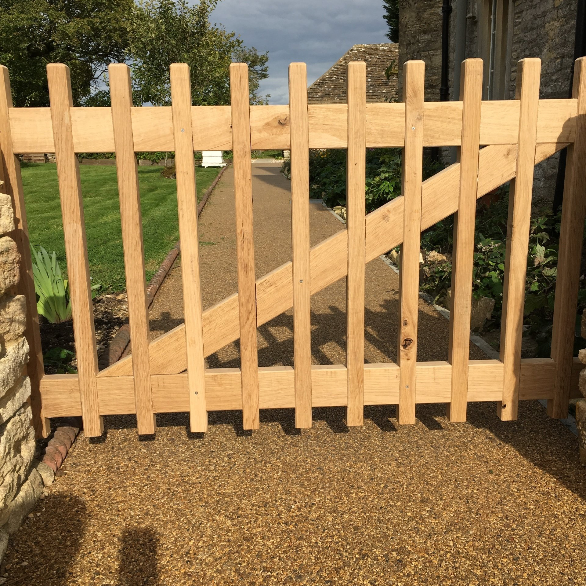 A wooden gate with a stone wall in the background