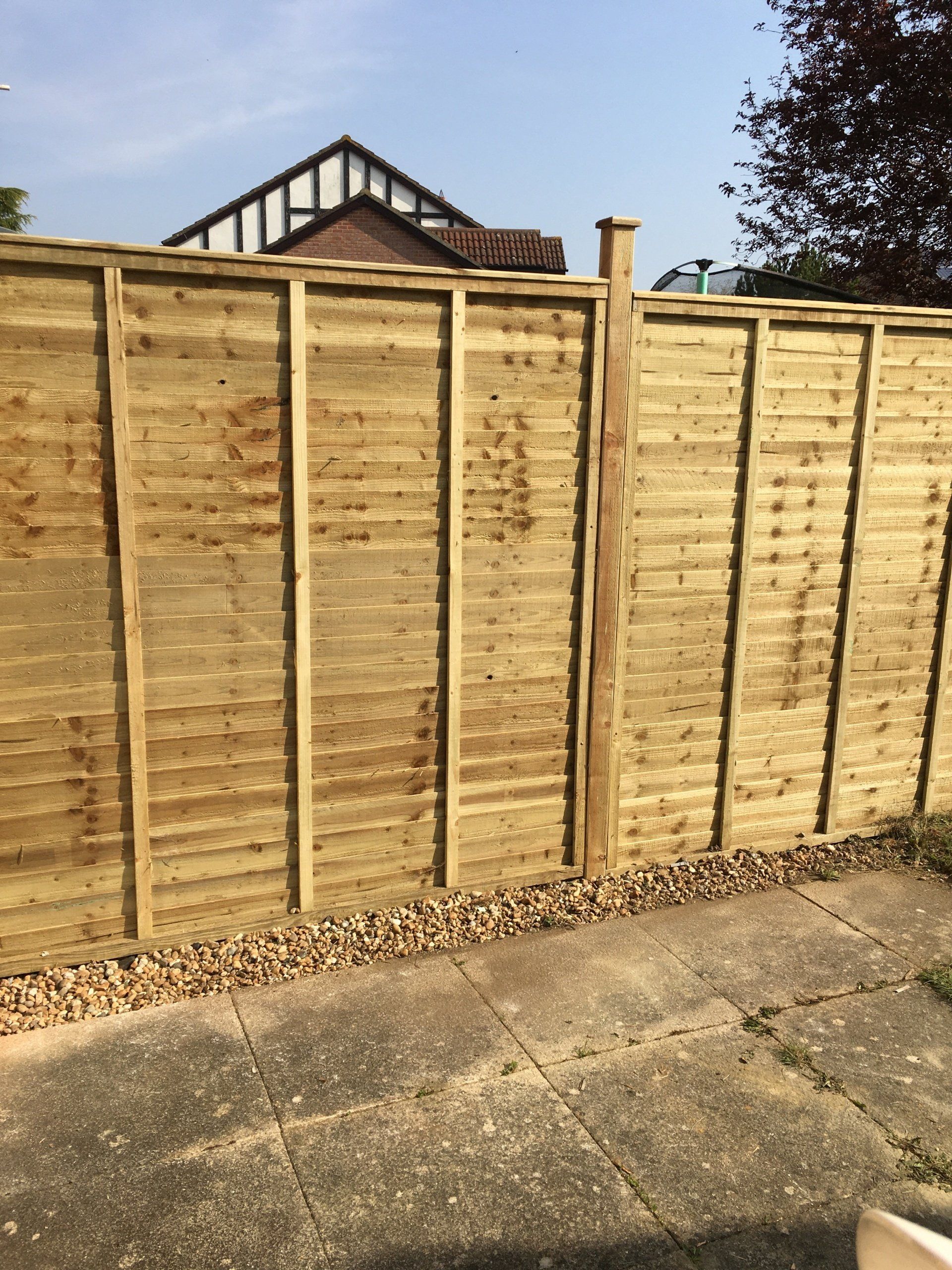 A wooden fence with a house in the background