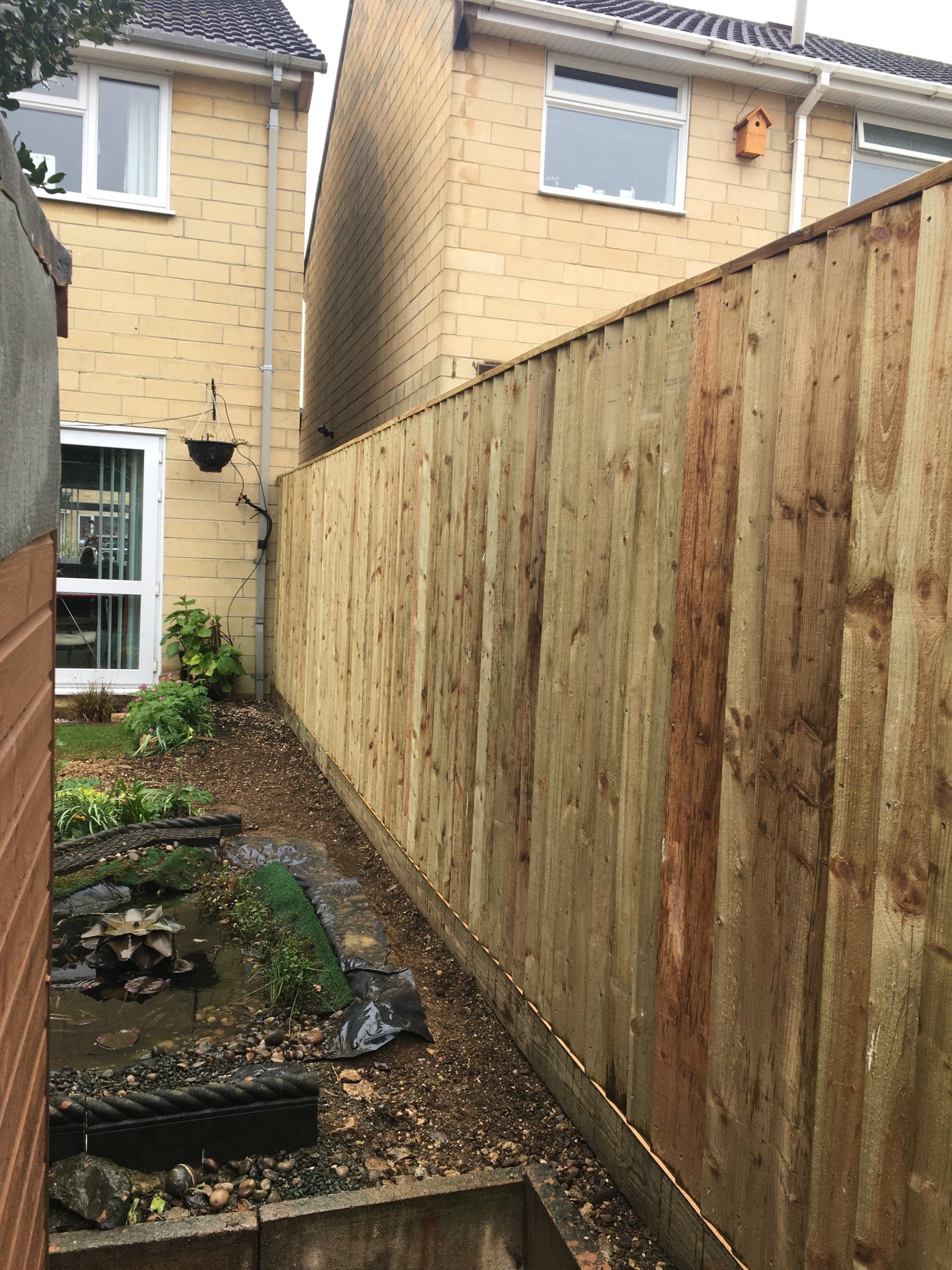 There is a wooden fence between two houses.