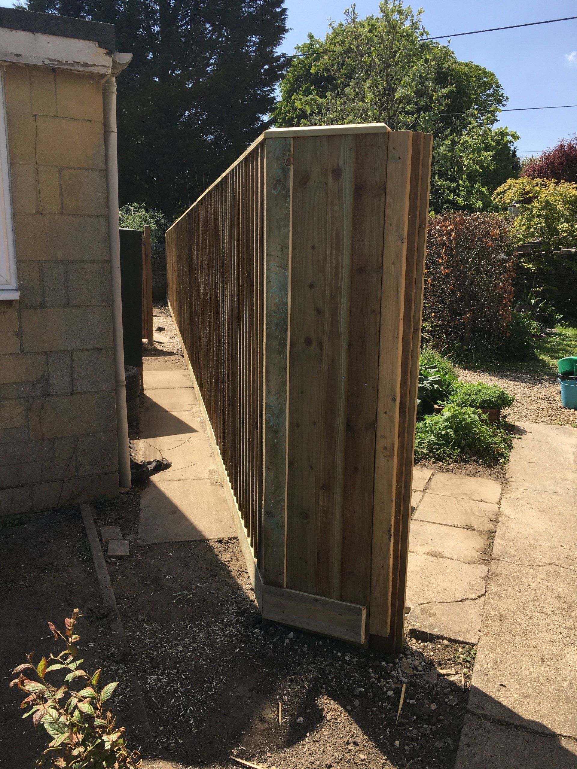 A wooden fence is being built next to a house