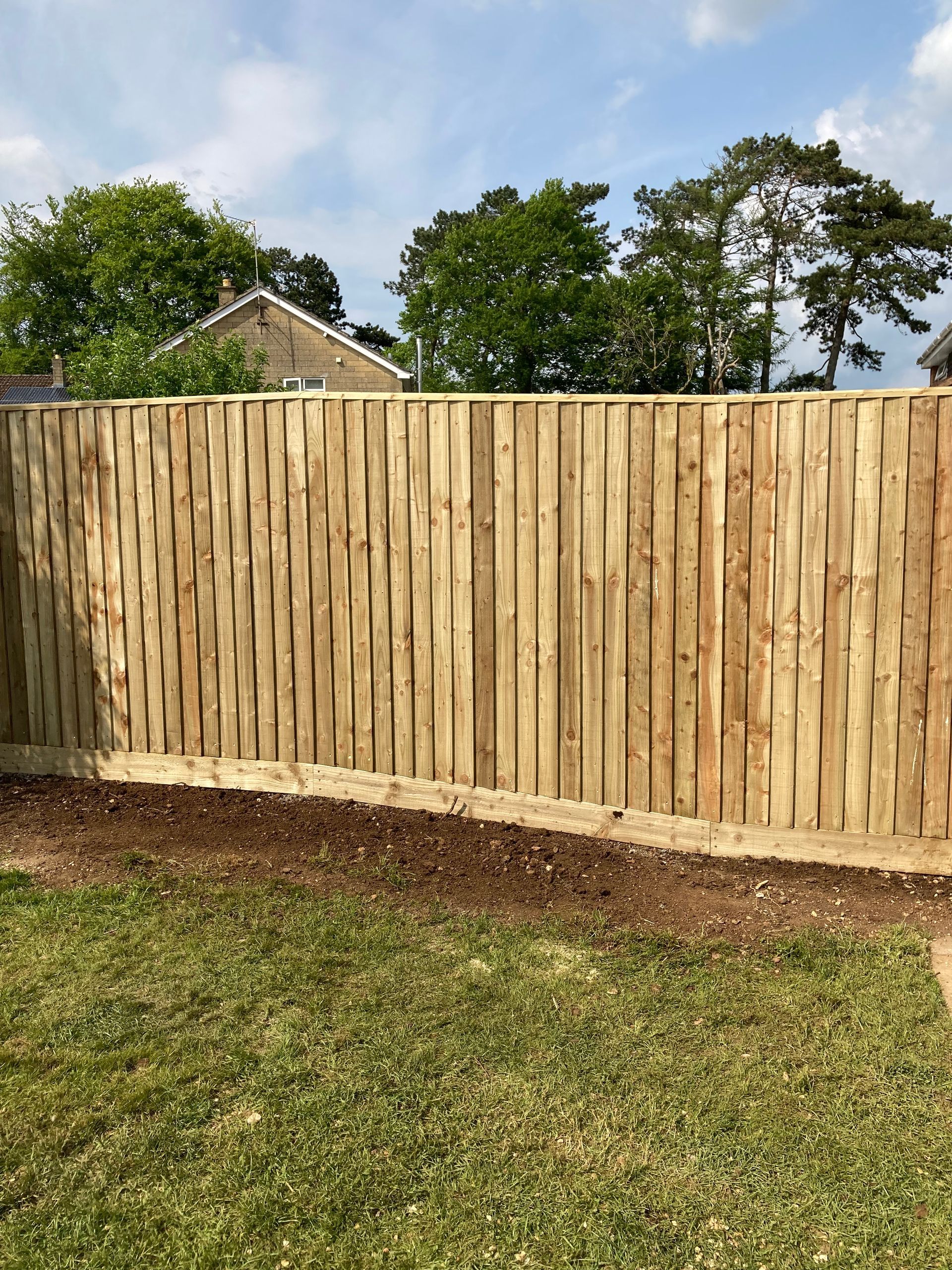 A wooden fence is sitting in the middle of a lush green field.