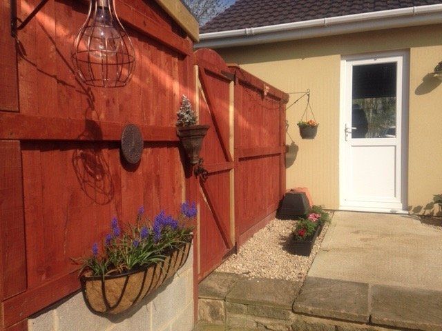 A red fence with a basket of flowers on it