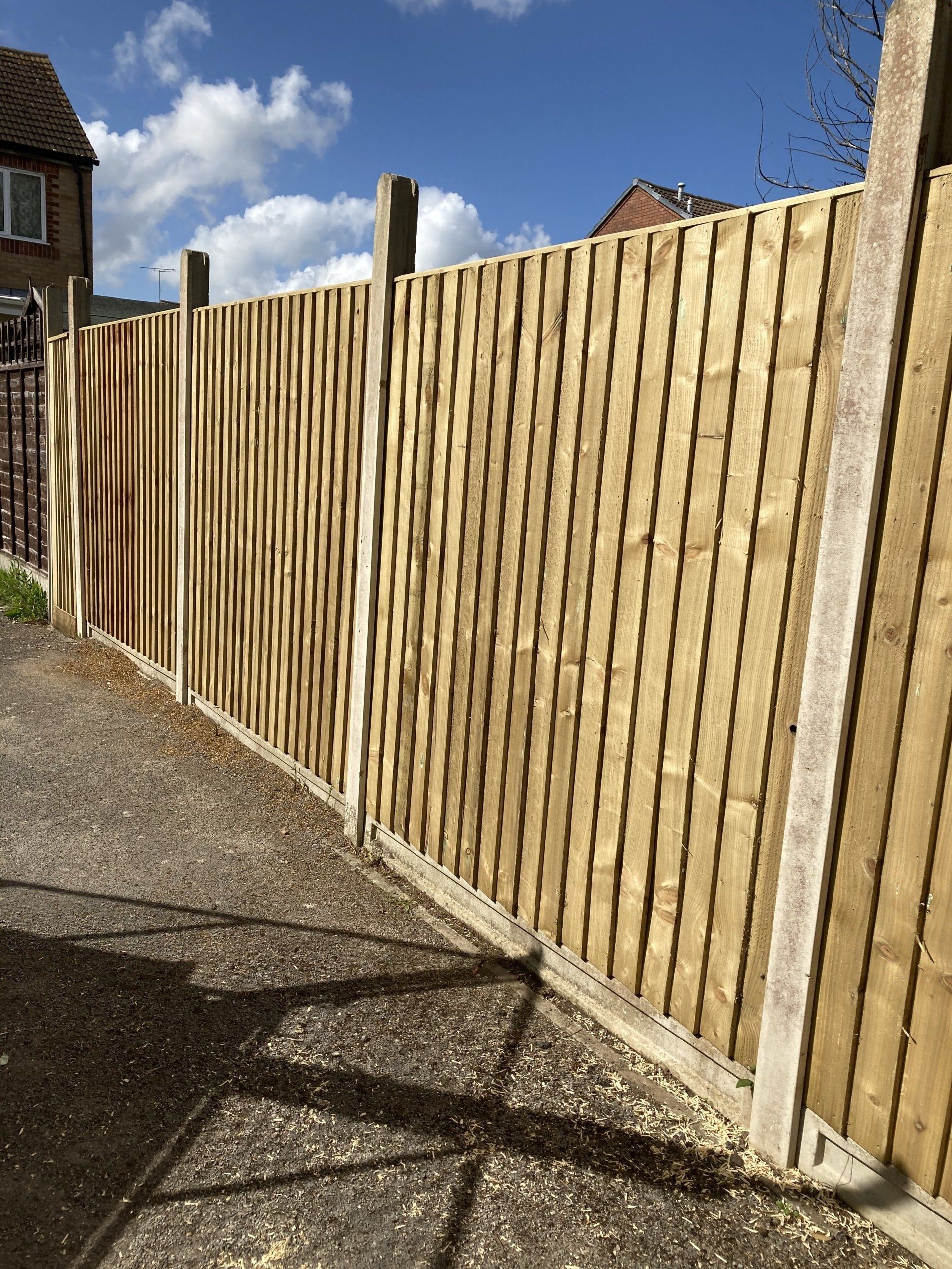 A wooden fence is sitting on the side of a road.