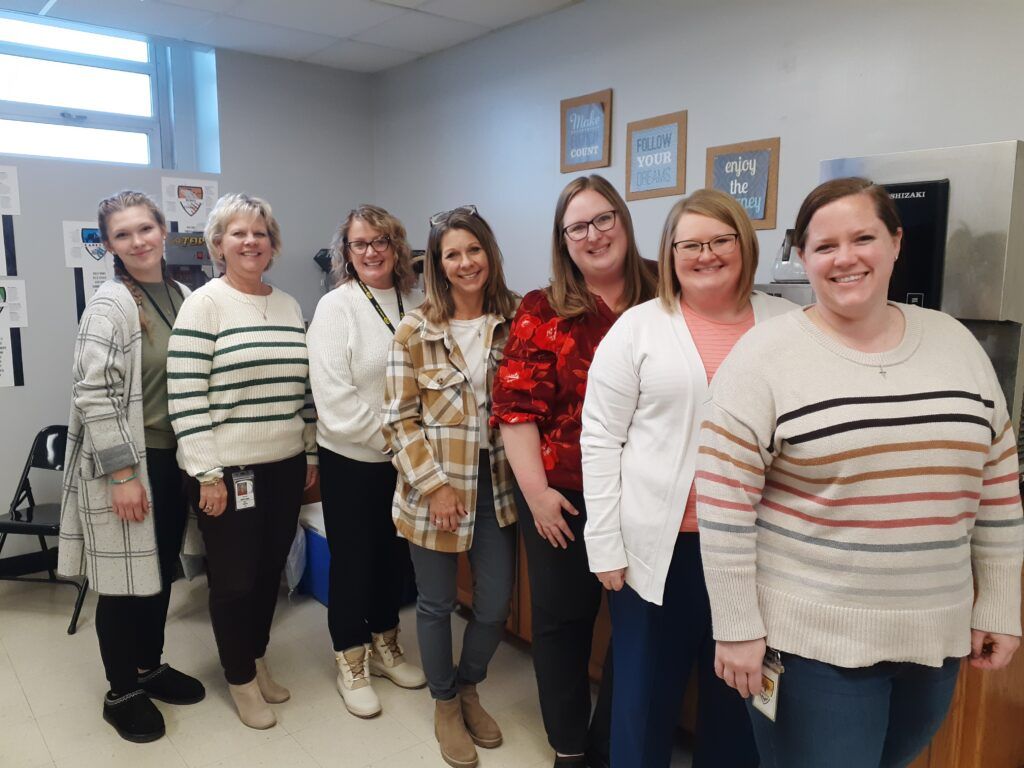 A group of women are posing for a picture in a room.