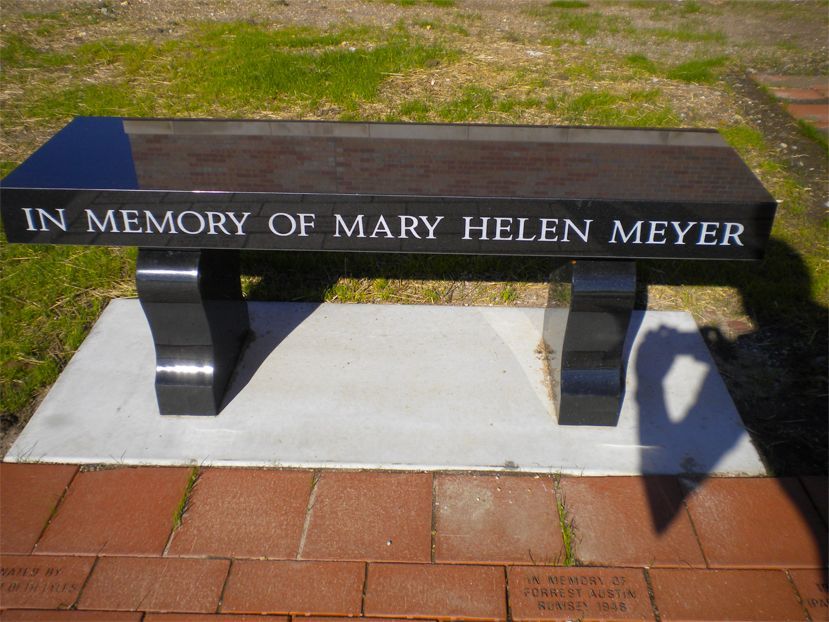 A black bench with the words in memory of mary helen meyer on it