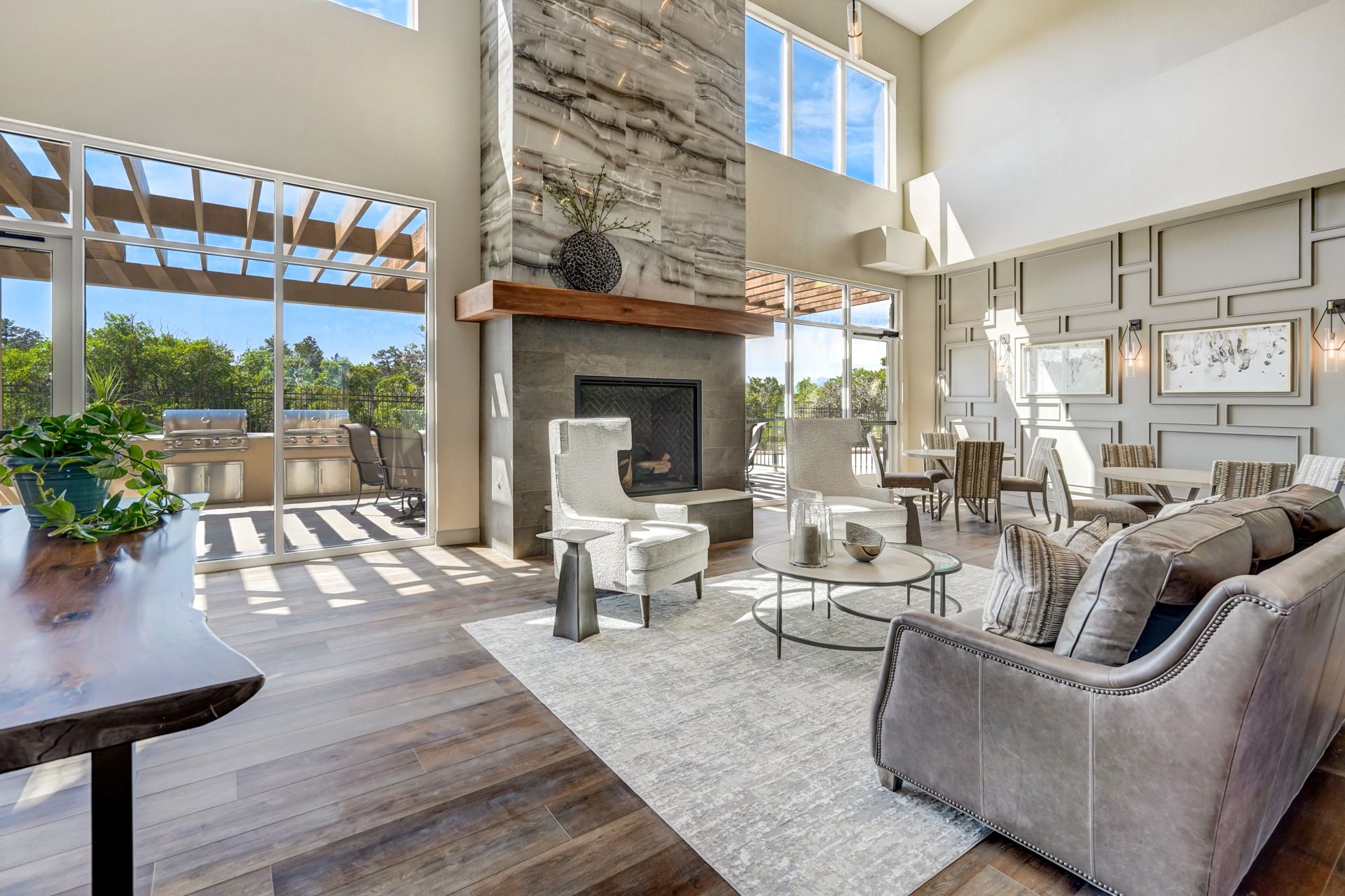 Spacious living room with fireplace, seating area, and outdoor patio access; neutral tones and natural light.