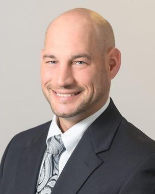 A man in a suit and tie is smiling for the camera.