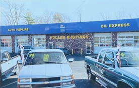 Cars are parked in front of a building that says oil express