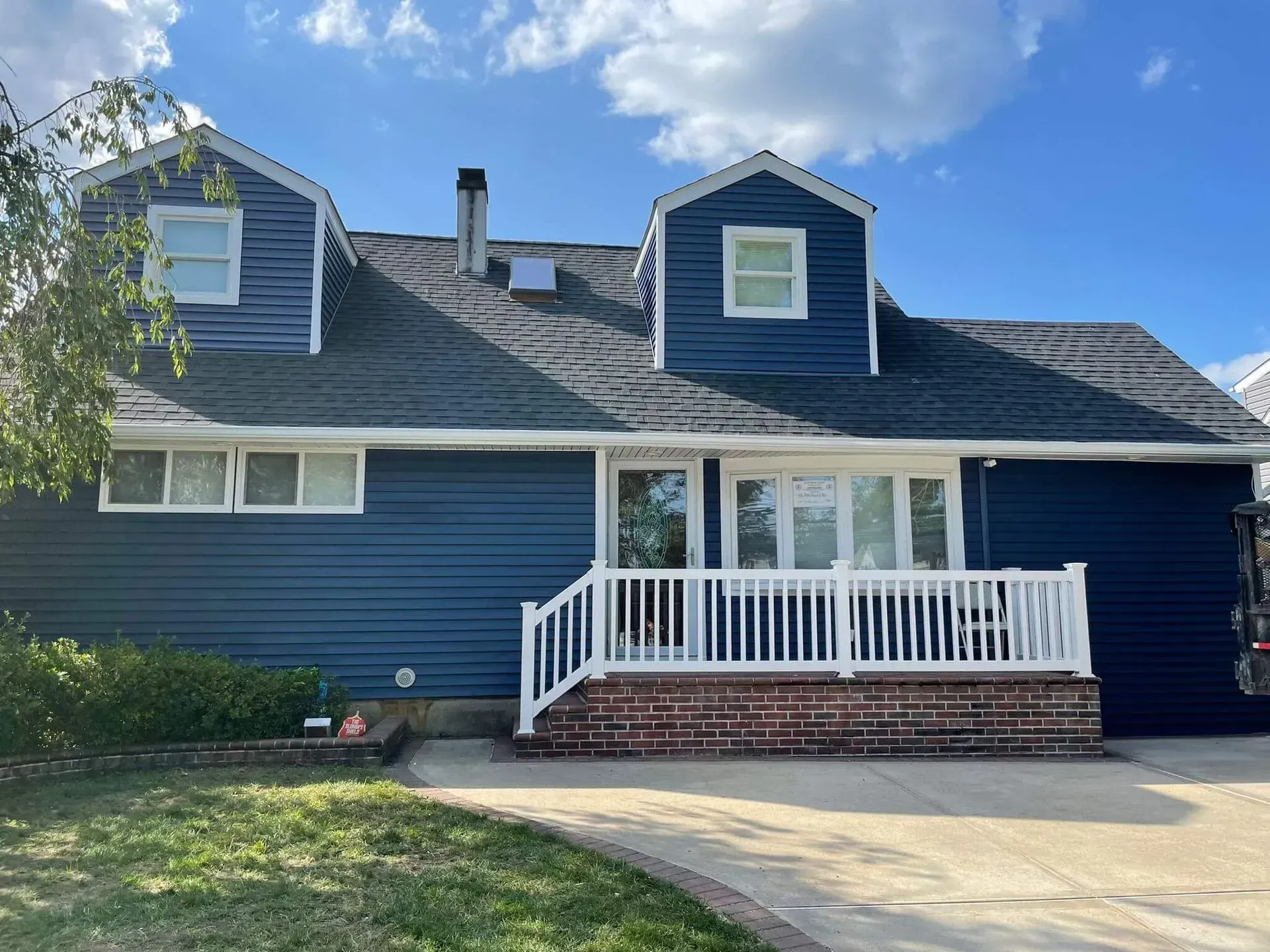 A blue house with a white porch and stairs