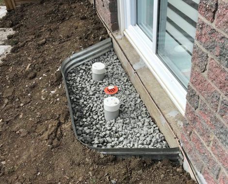 Un système de drainage est en cours d'installation sur le côté d'une maison.