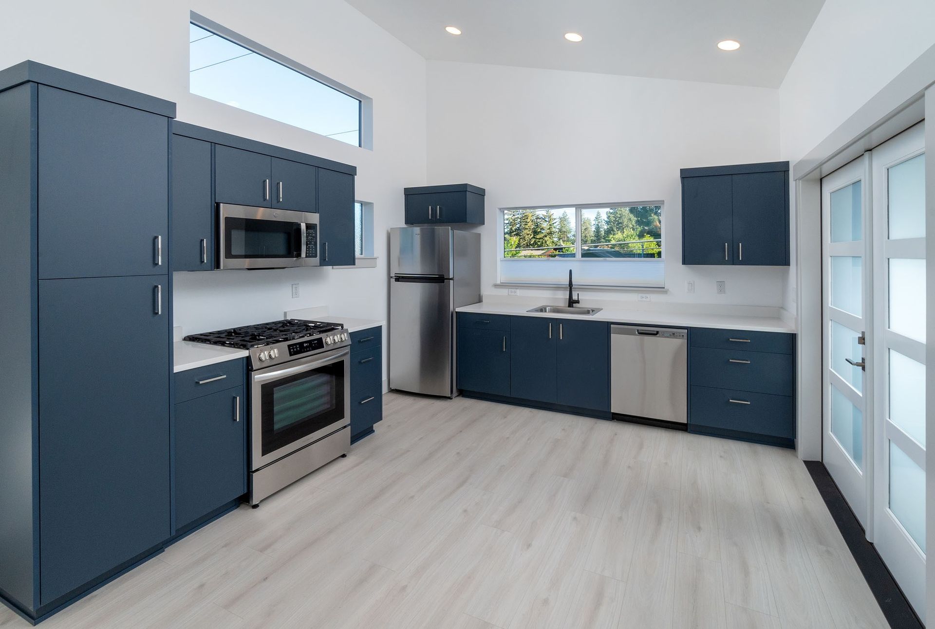 A kitchen with blue cabinets and stainless steel appliances