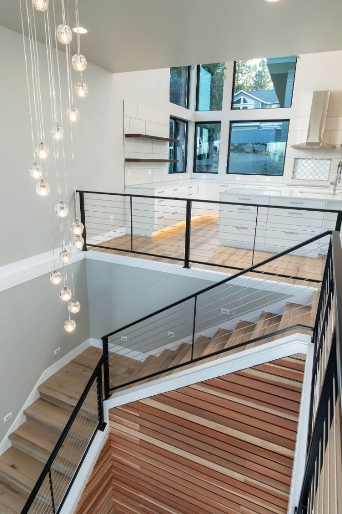 A staircase with a glass railing and wooden steps in a house.
