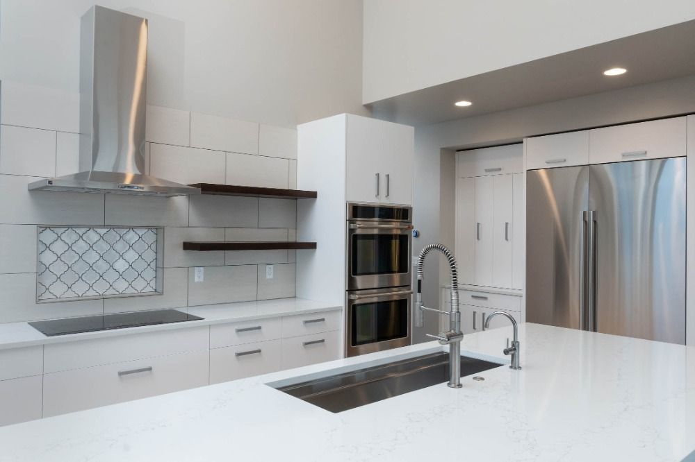 A kitchen with white cabinets and stainless steel appliances