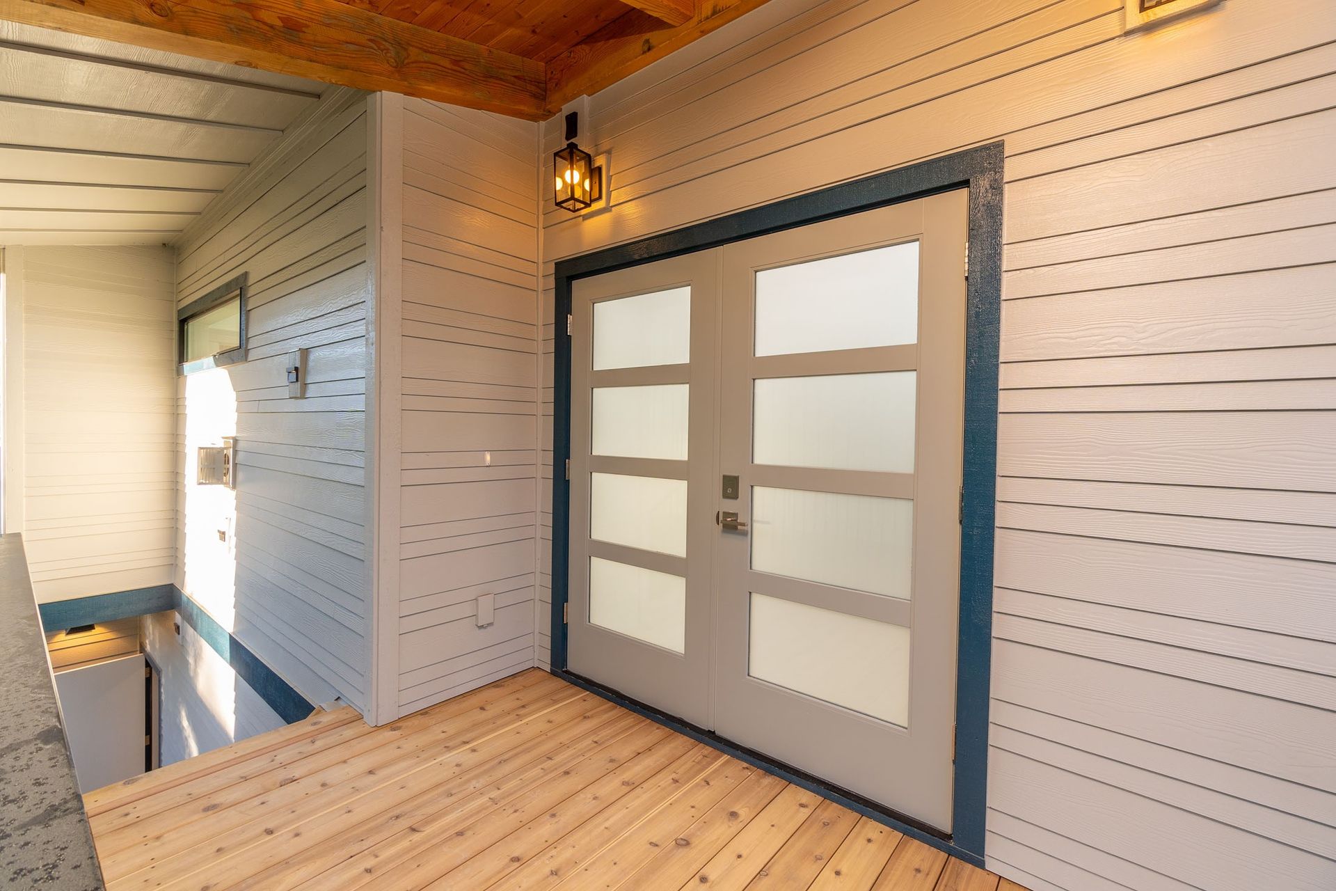 A hallway with a double door and a wooden floor.
