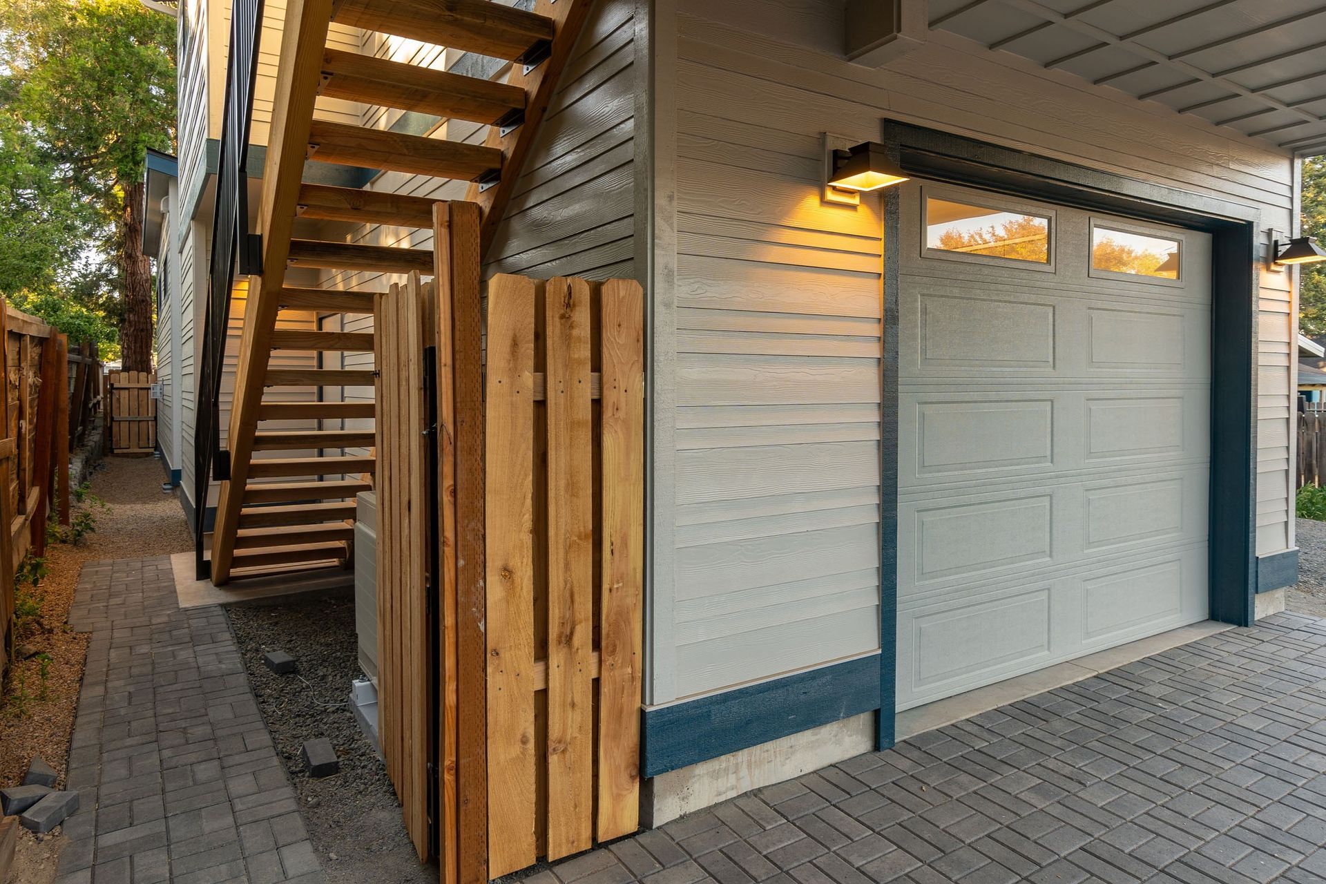 A garage with a wooden fence and stairs next to it.