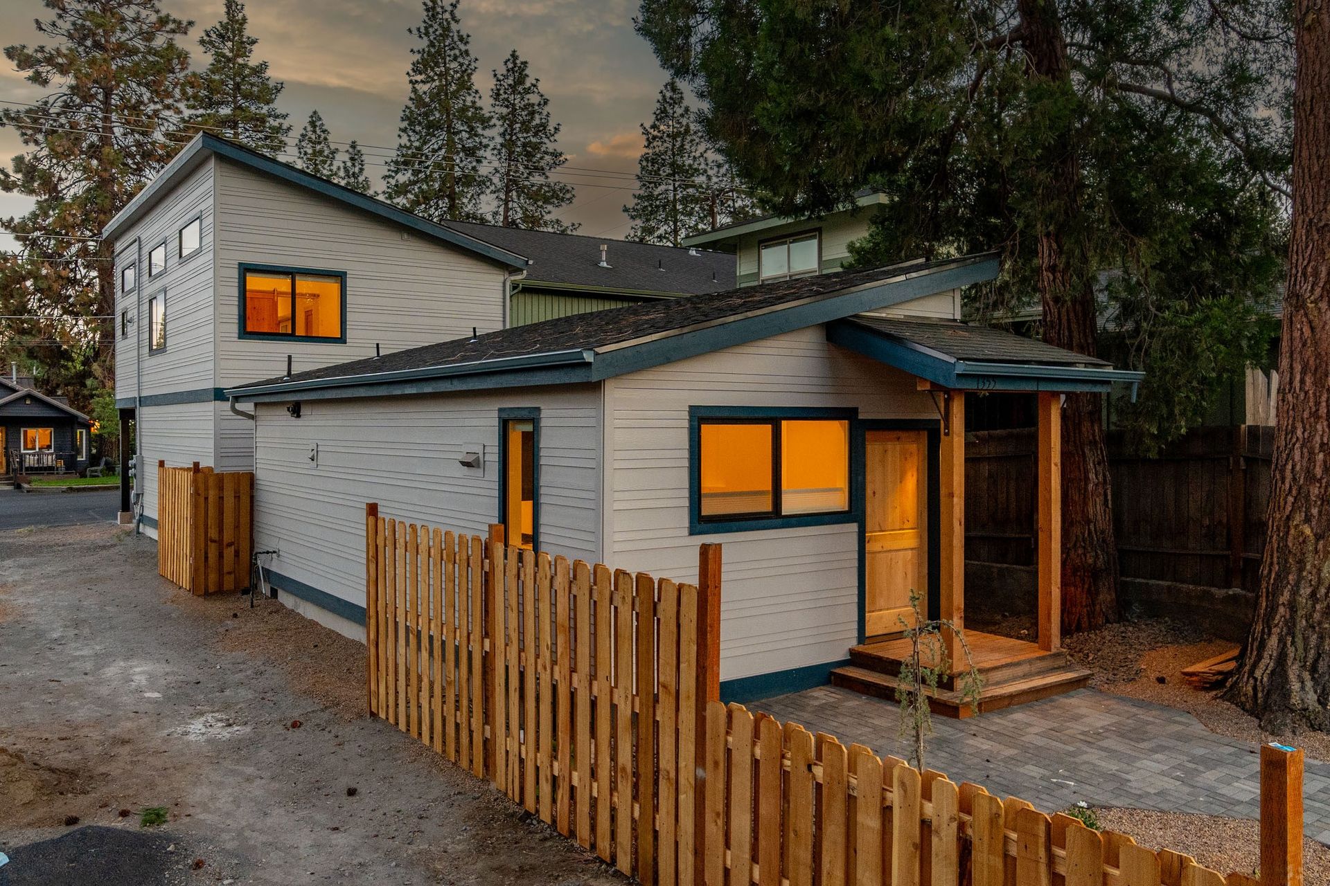 A small white house with a wooden fence around it.