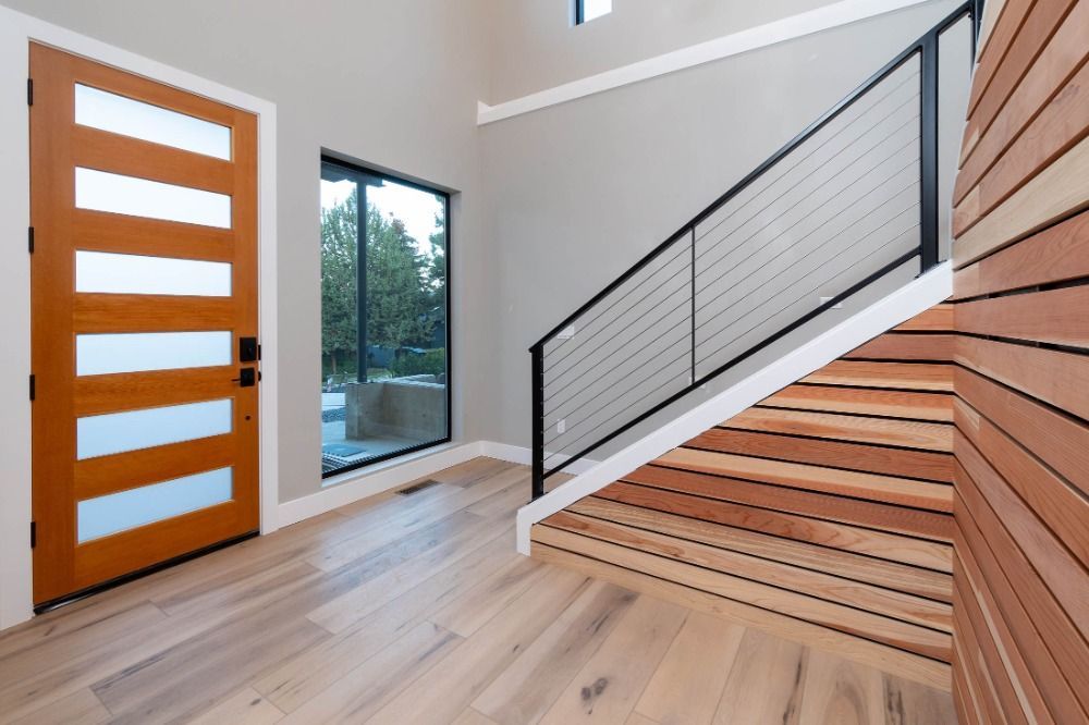 An empty room with a wooden staircase and a wooden door