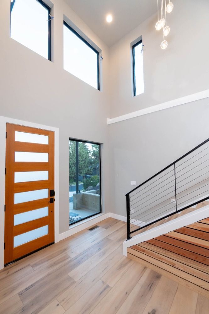 An empty hallway with a staircase and a door