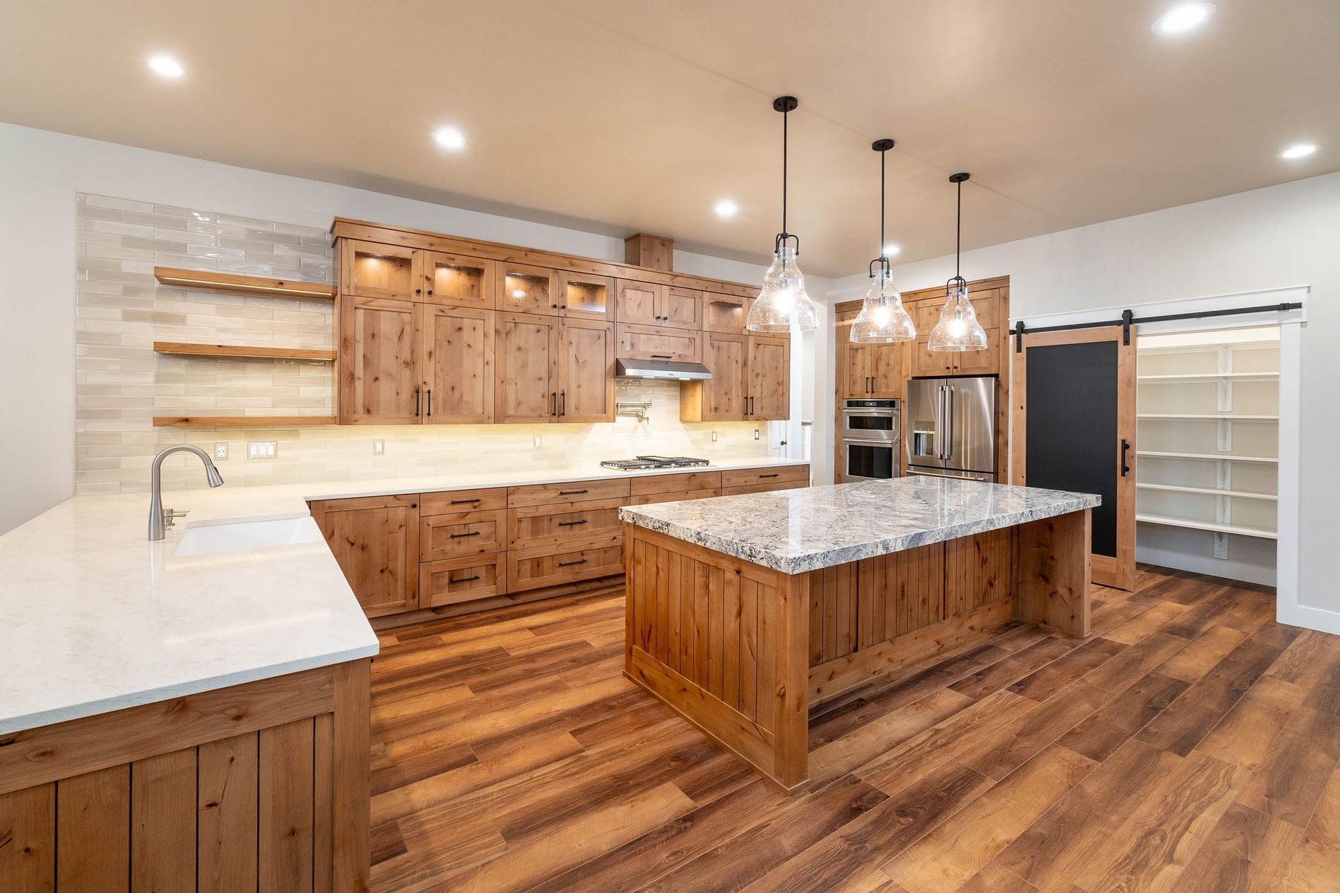 A kitchen with wooden cabinets , granite counter tops , and a large island.