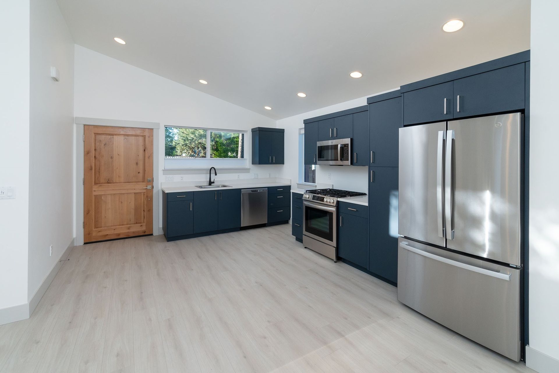 A kitchen with stainless steel appliances and blue cabinets