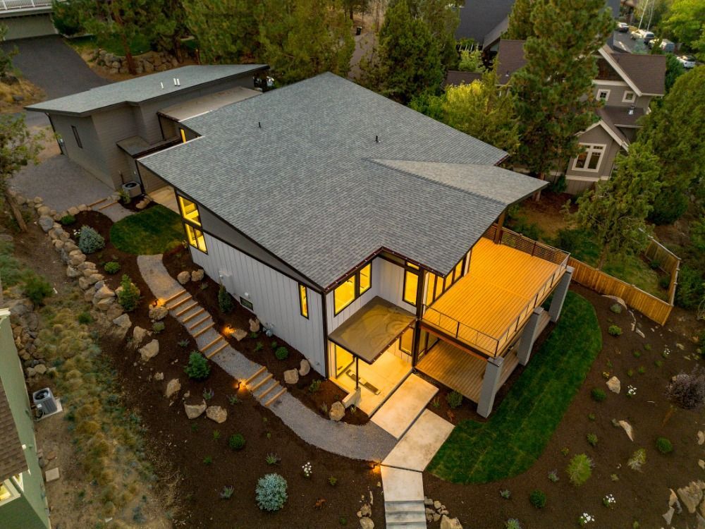 An aerial view of a house with a large deck and stairs leading to it.