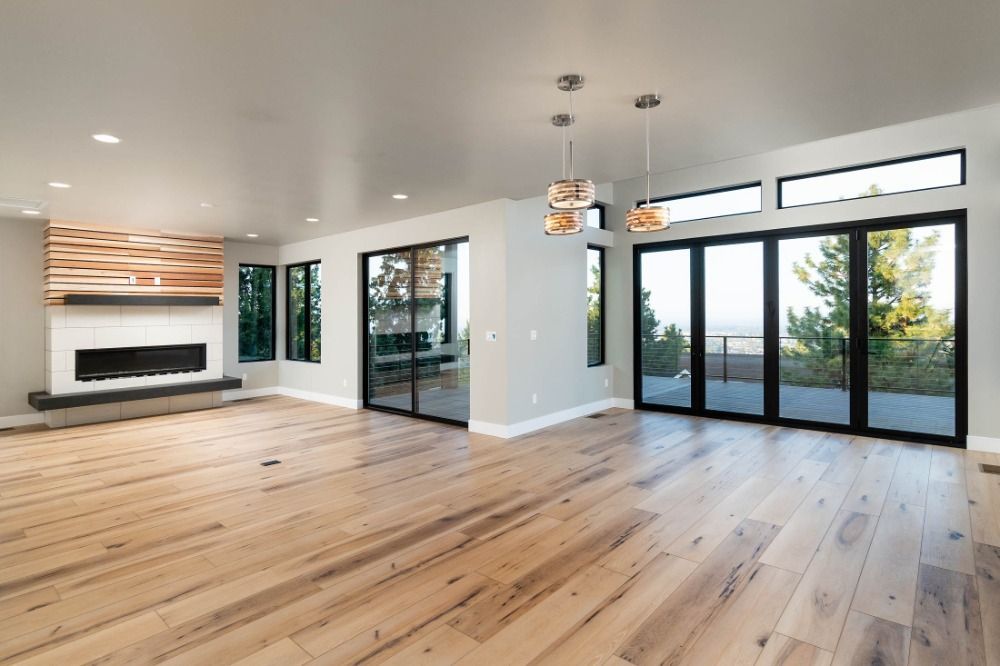 An empty living room with hardwood floors and a fireplace.
