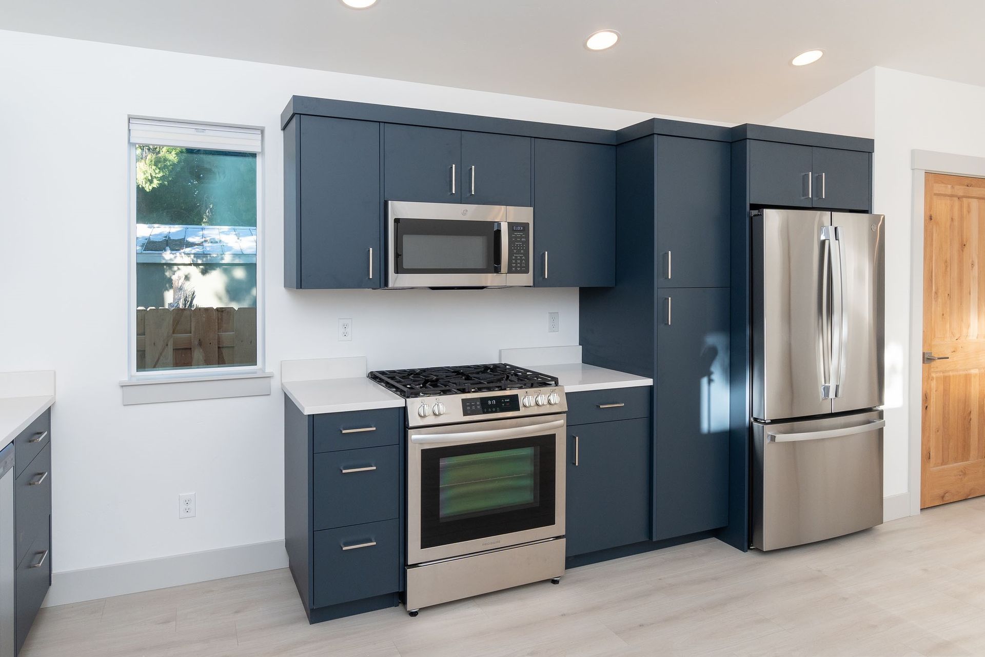A kitchen with stainless steel appliances and blue cabinets