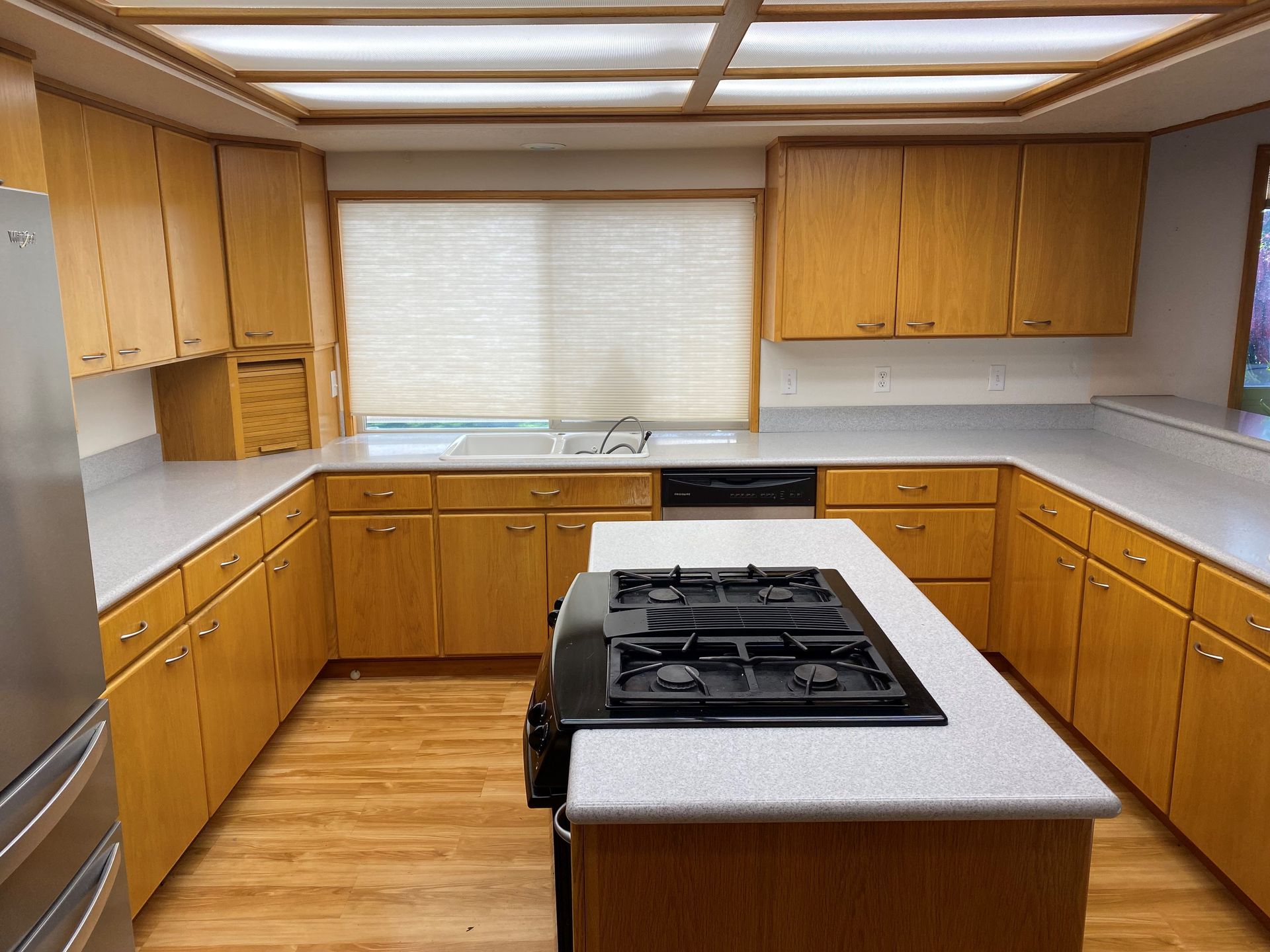 A kitchen with wooden cabinets and a stove top oven