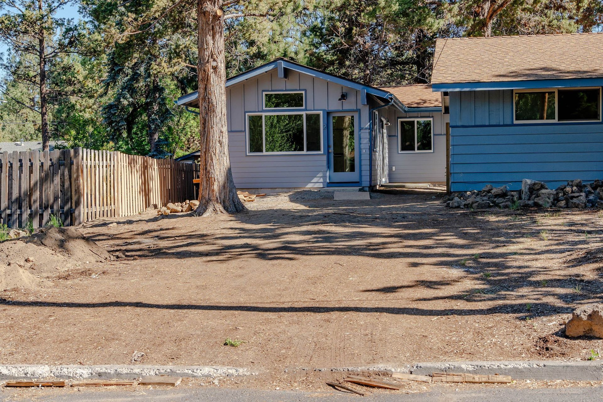 A blue and white house with a fence in front of it