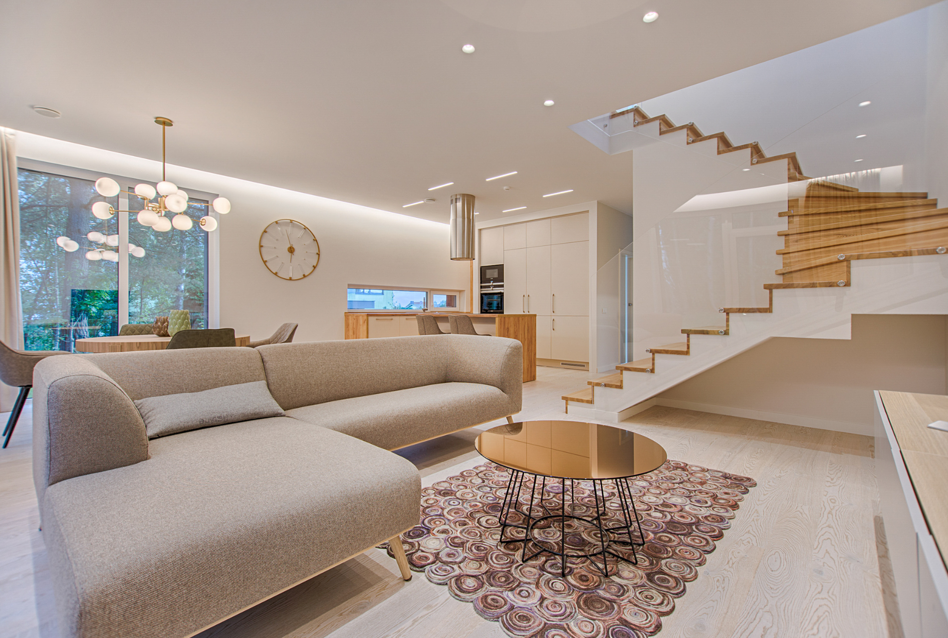 A living room with a couch , coffee table , and stairs.